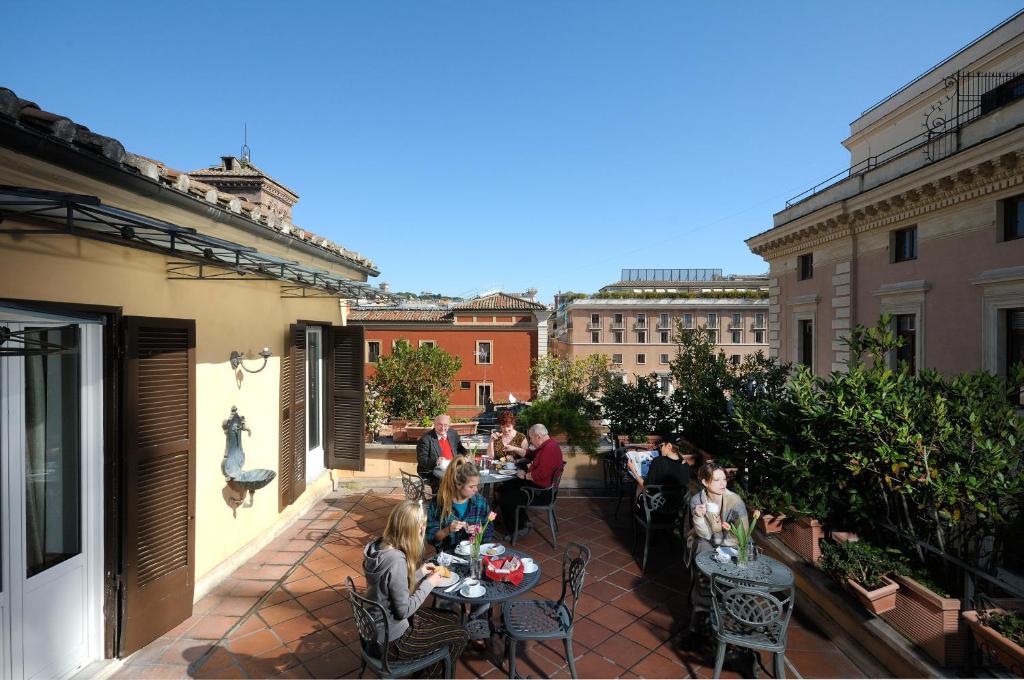 罗马帕拉门托精品酒店的坐在庭院桌子上的一群人