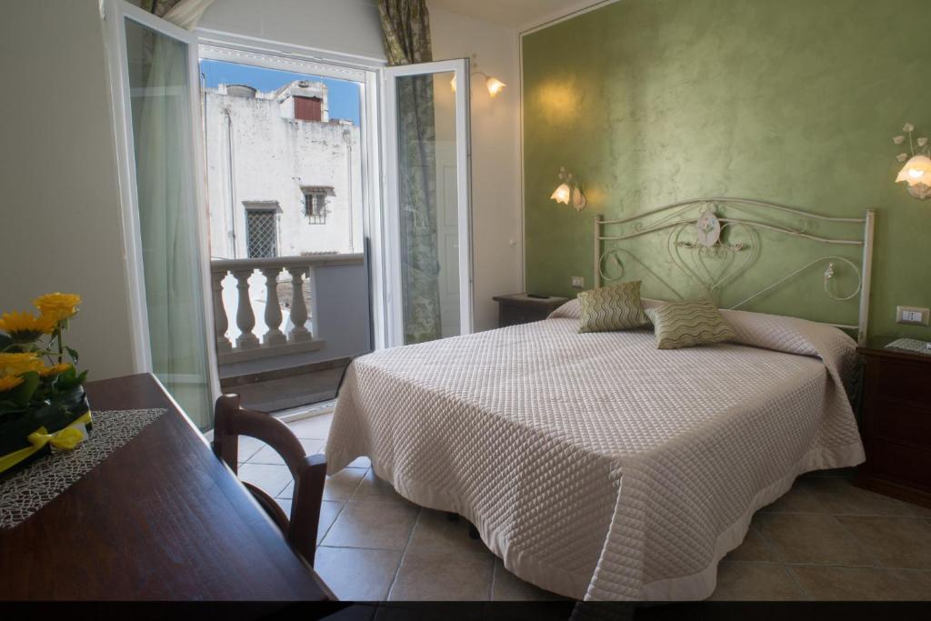 塔维亚诺B&B Corte dell' Immacolata的卧室配有白色的床和窗户。