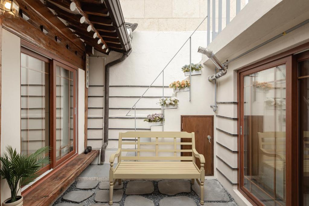 首尔Sabrina at Hanok的坐在建筑物边的木凳
