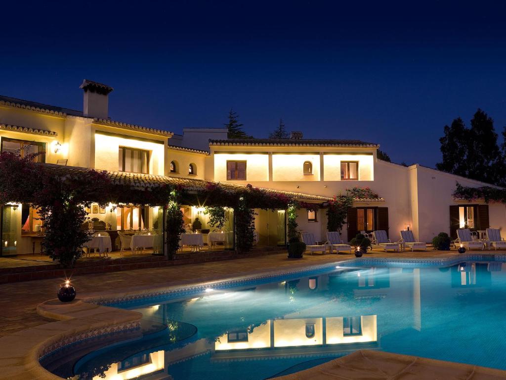 贝尼萨Boutique Hotel La Madrugada的一座在晚上设有游泳池的大房子