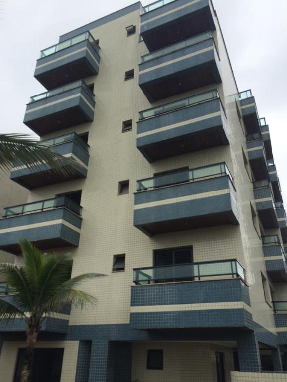 乌巴图巴Apartamento 2 Quartos Vista Mar的带阳台和棕榈树的高公寓大楼