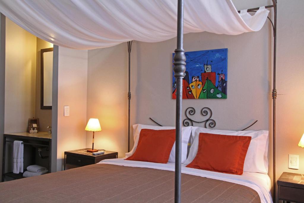 布宜诺斯艾利斯A酒店的一间卧室配有带橙色枕头的天蓬床