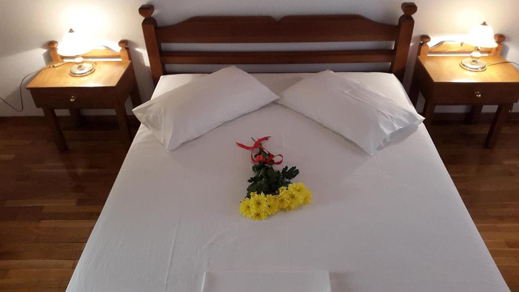 特尔斐Epic Rooms的一张白色的床,上面插着花