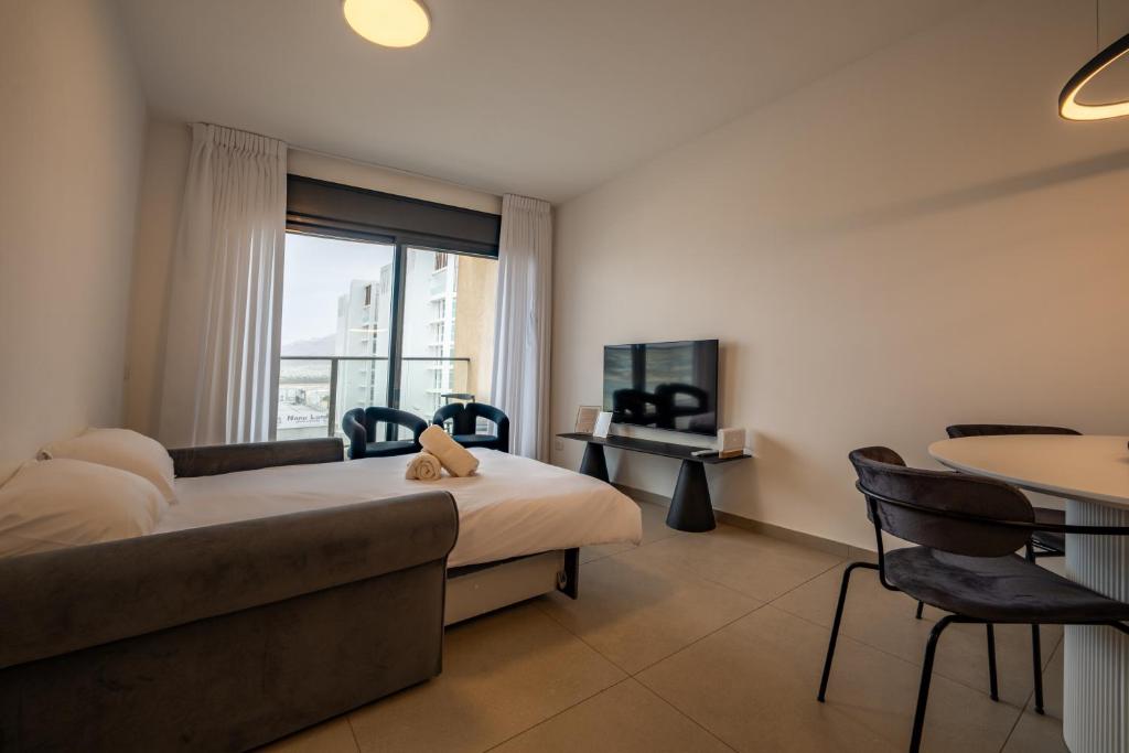 埃拉特Valencia Apartment - By Harim的一间配有床、沙发和桌子的酒店房间