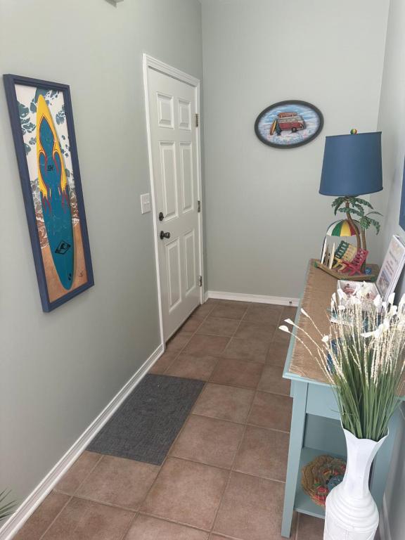 格尔夫海岸Beautiful Two Bedroom, Two Bathroom First Floor Condo in Gulf Shores!的走廊上挂着一张桌子和一张墙上的照片