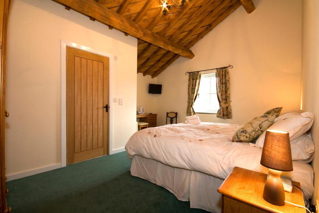 Burscough伯斯法姆酒店的一间卧室配有一张床和一张带台灯的桌子