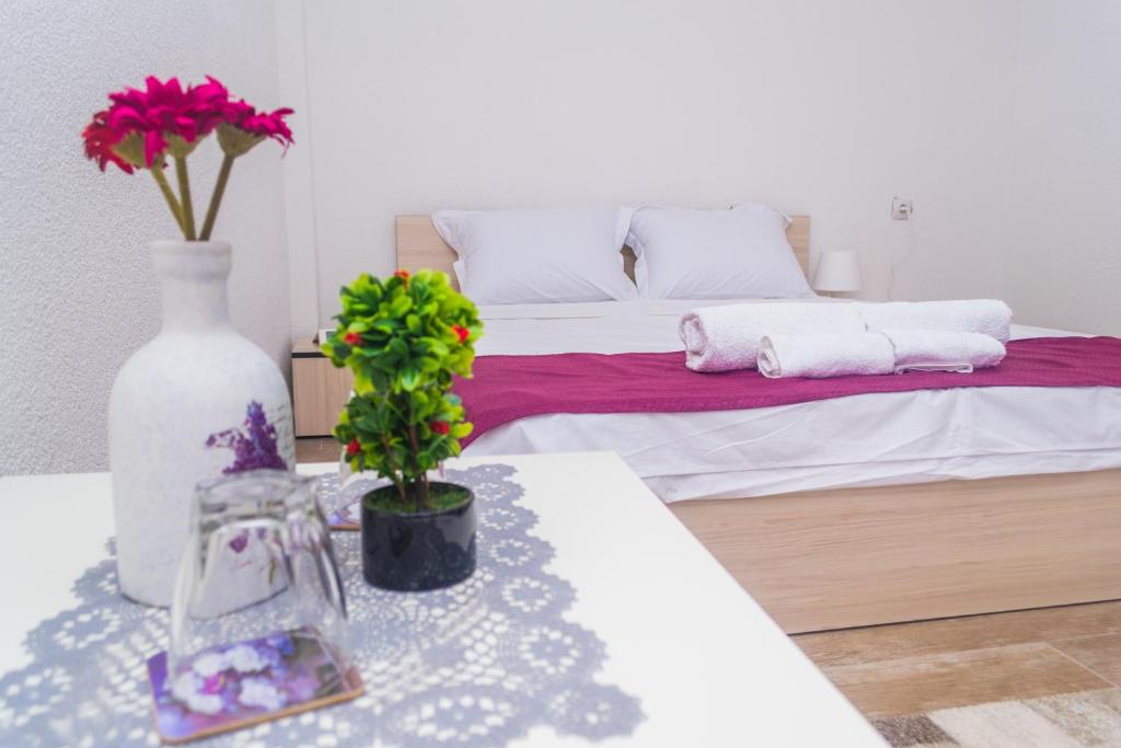 StojakovoBed & Breakfast Delikates的一间卧室配有一张床和一张鲜花桌子
