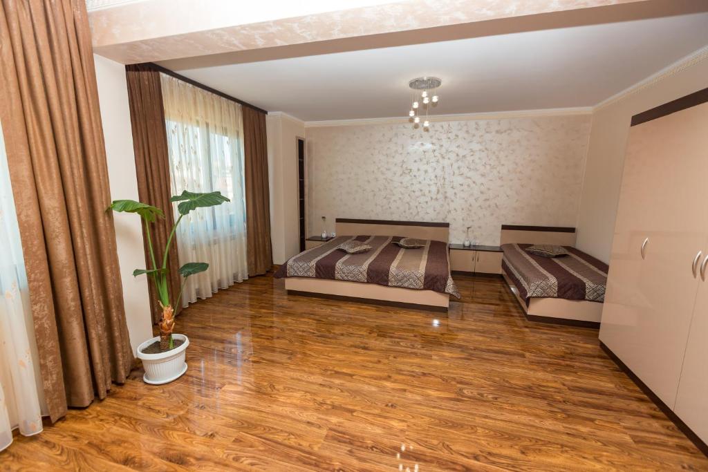 多斯帕特Hotel Kristal的一间卧室设有两张床和盆栽植物