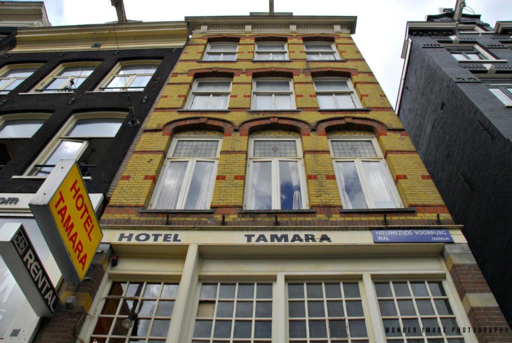 阿姆斯特丹塔玛拉酒店的一座高大的砖砌建筑,上面有酒店塔马拉