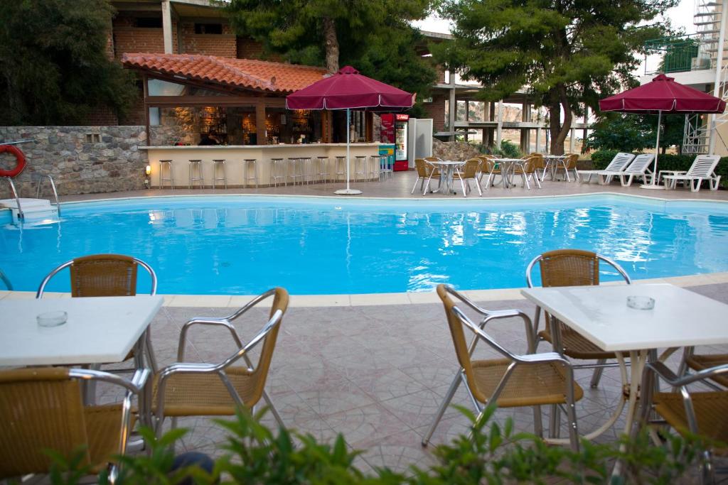 托隆伊斯佩里亚酒店的大楼前的带桌椅的游泳池
