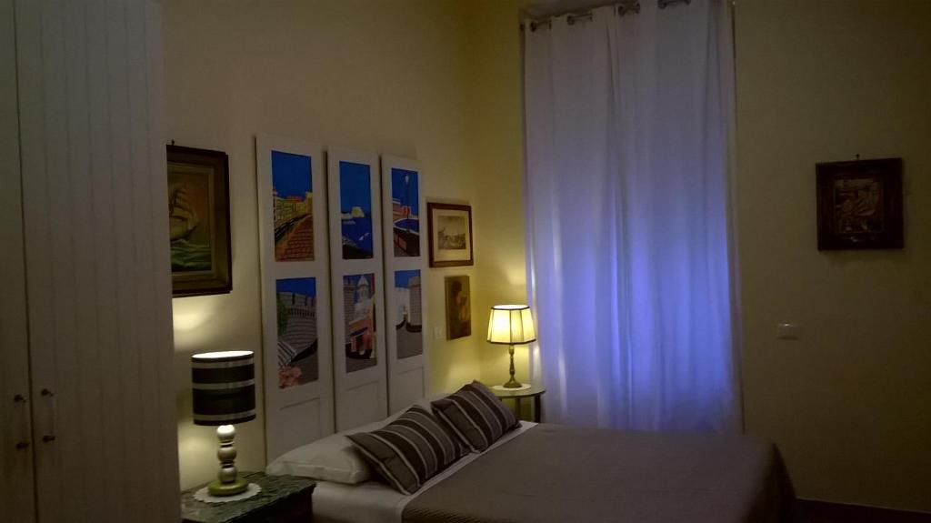那不勒斯安吉拉之家酒店的一间卧室设有床、窗户和一盏灯。