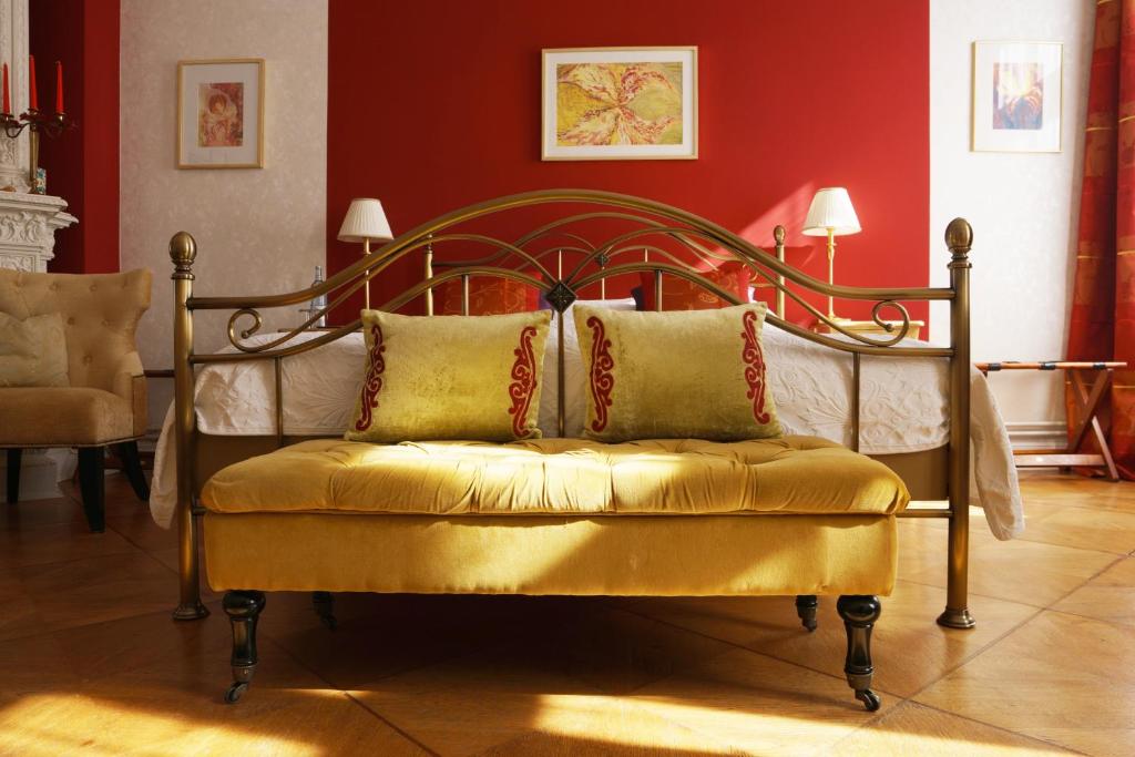 柏林Boutique Hotel Mittendrin Berlin的一张床上,在房间里摆放着金色长椅