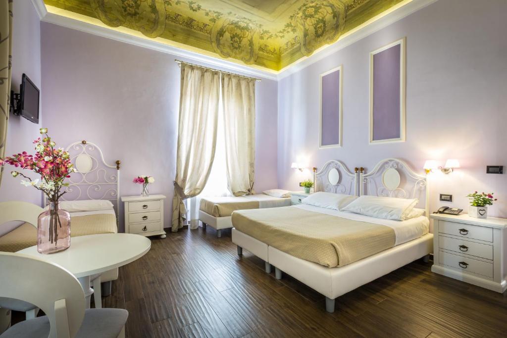 佛罗伦萨费鲁奇酒店的一间卧室配有两张床和一张鲜花桌