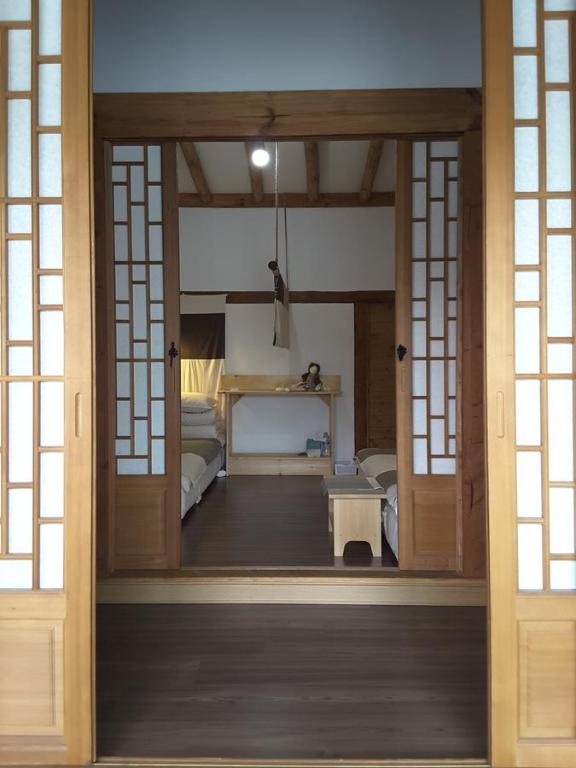 庆州耶陶尔韩屋旅馆的通向带卧室的房间的开放式门