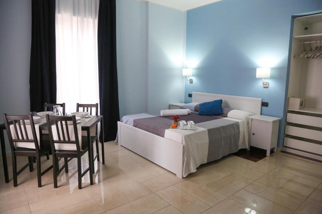 玛格丽塔萨沃亚Napolitano Palace的卧室配有一张床和一张桌子及椅子