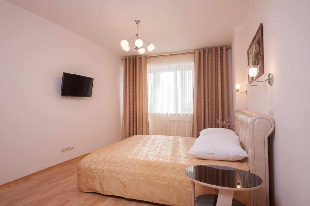 克拉斯诺亚尔斯克Apartment na Vodopyanogo的一间小卧室,配有一张床和一张桌子