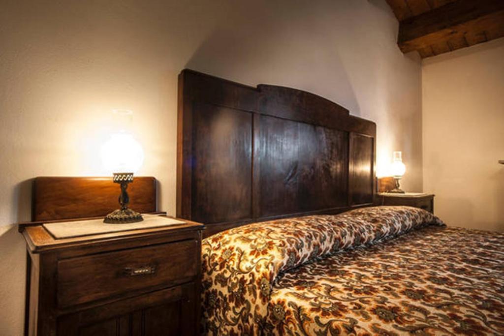 Santa Sofia dʼEpiroAgriturismo Miracco Atanasio Franco "Il Maniero"的一间卧室配有一张大床和大型木制床头板