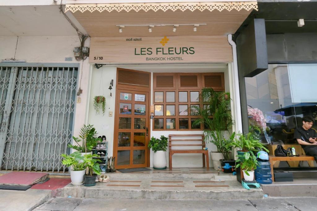 曼谷Les Fleurs Bangkok Hostel的商店的前门,里面装有长凳