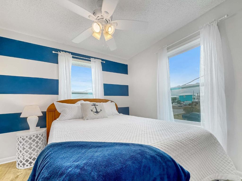 格尔夫海岸Bungalow by the Bay with FREE ACTIVITIES的蓝色和白色的卧室设有床和窗户
