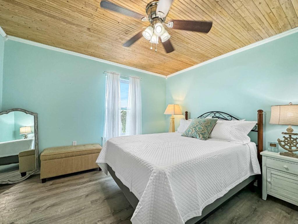 格尔夫海岸Bungalow by the Bay with FREE ACTIVITIES的带床和吊扇的卧室