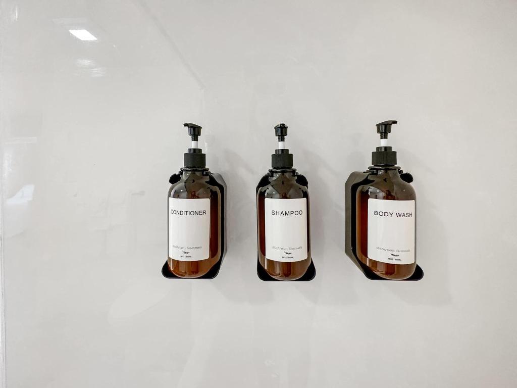 格尔夫海岸Bungalow by the Bay with FREE ACTIVITIES的坐在一张白色桌子上的三瓶肥皂