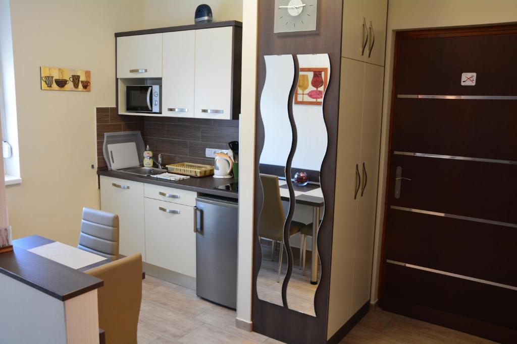 埃格尔Bodza Apartmanok的厨房旁边设有厨房柜台,配有冰箱