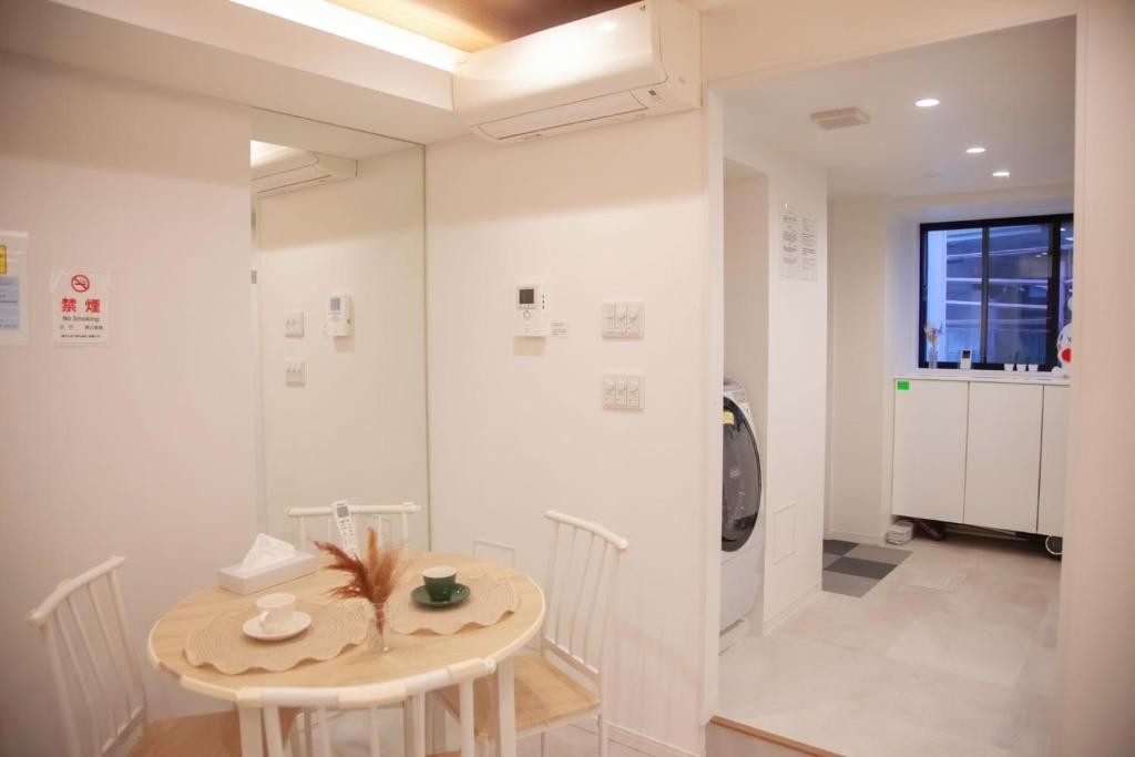 东京森下小屋的白色的客房配有桌子和洗衣机。