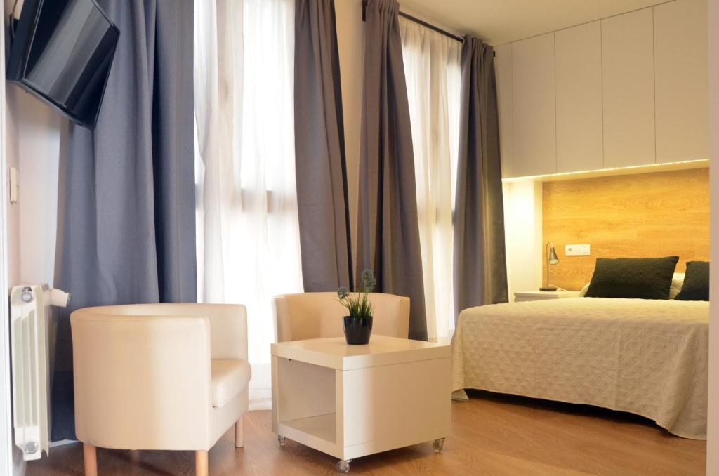 科尔多瓦科尔多吧中庭公寓的一间卧室配有一张床、一把椅子和一张桌子
