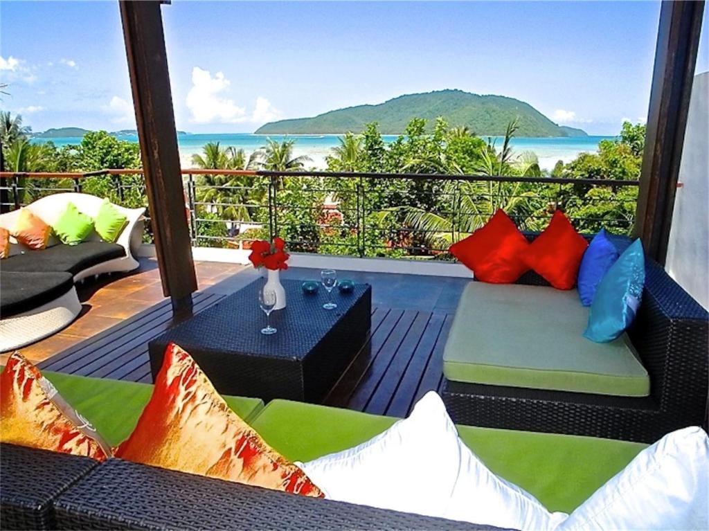 拉威海滩伊娃拉威三卧室私人泳池别墅的阳台配有沙发,享有海景。