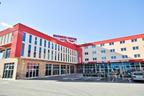 萨拉热窝BM国际酒店的一座大型建筑,前面设有停车场