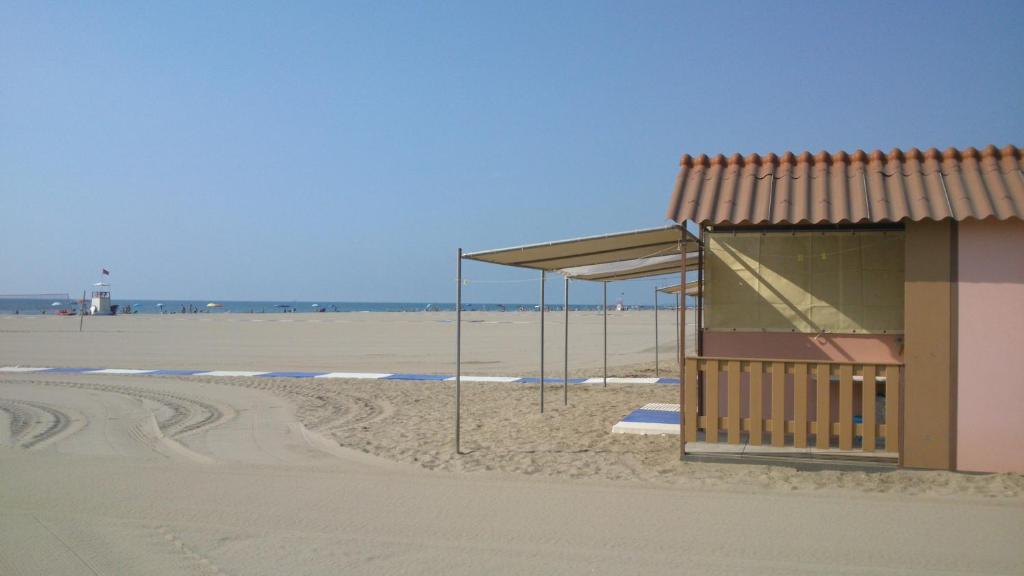 威尼斯丽都特拉马尔拉姑纳住宿加早餐旅馆的海滩上的公共汽车站,有一座建筑