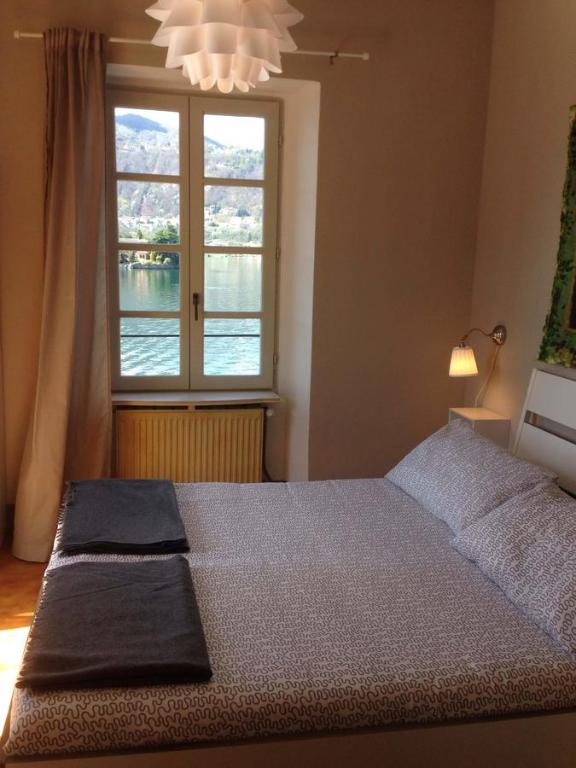 奥尔塔圣朱利奥-Ortaflats- Appartamento L'Angolo的一间卧室设有一张大床和大窗户
