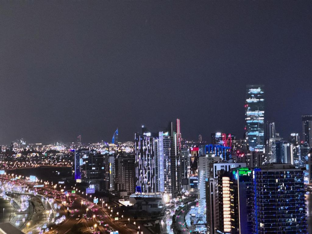迪拜CaiCai Homes 1 BHK Nobles Tower Business Bay 5 min Drive to Dubai Mall的夜晚带灯光的城市景观