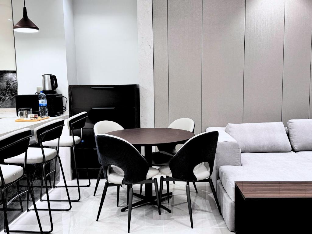 迪拜CaiCai Homes 1 BHK Nobles Tower Business Bay 5 min Drive to Dubai Mall的带沙发、桌子和椅子的客厅