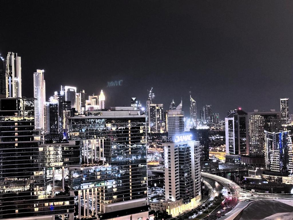 迪拜CaiCai Homes 1 BHK Nobles Tower Business Bay 5 min Drive to Dubai Mall的城市的夜视,有很多建筑