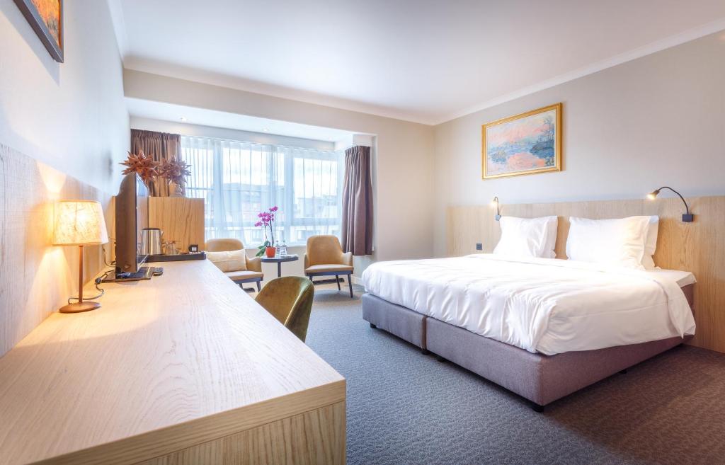 根特卡尔顿酒店的酒店客房设有一张床和一个大窗户