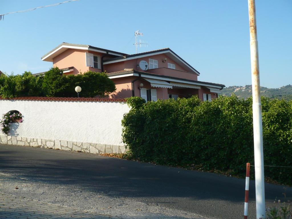 因佩里亚Azienda Agrituristica Villa Arianna的一条白色墙壁的街道边的房子