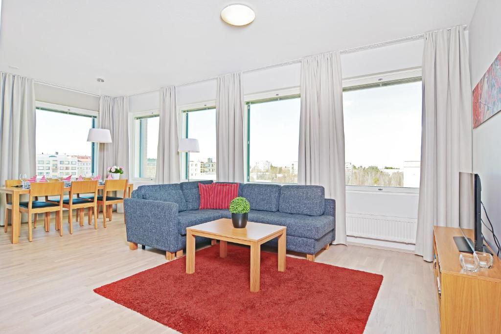 坦佩雷Forenom Serviced Apartments Tampere Pyynikki的客厅配有蓝色的沙发和桌子