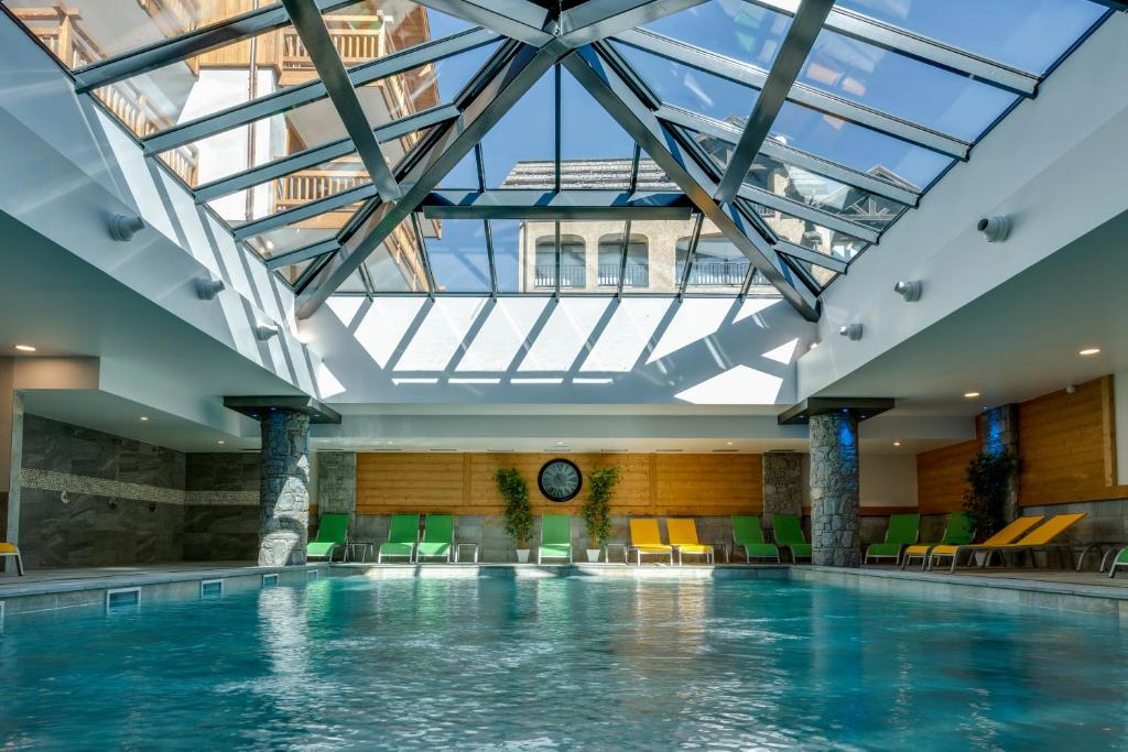 蒙热内夫尔CGH拿破仑Spa公寓的一座带天窗的建筑中的游泳池