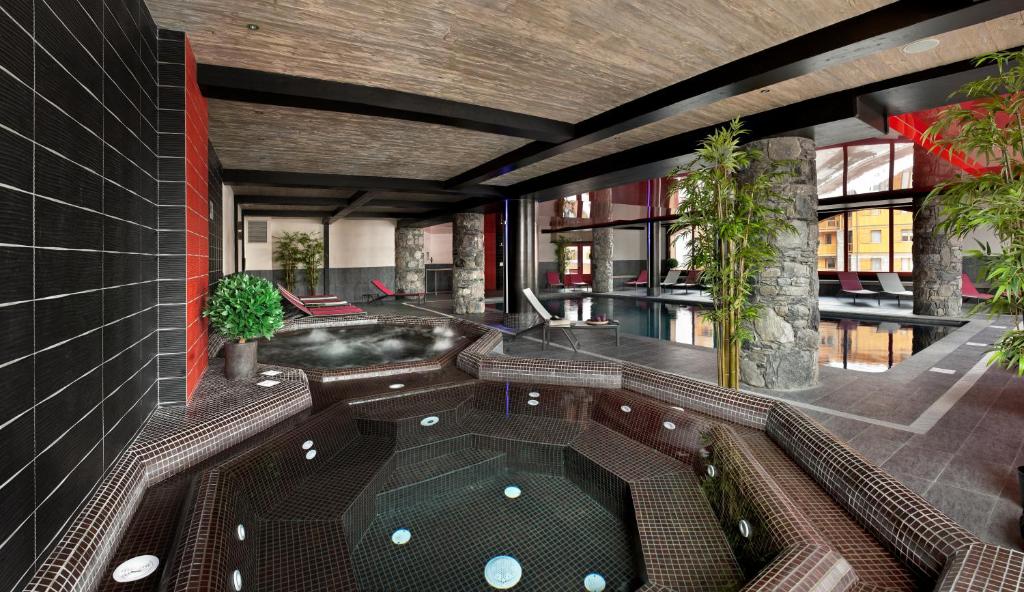 蒂涅CGH特勒马克公寓酒店的建筑中带按摩浴缸的房间