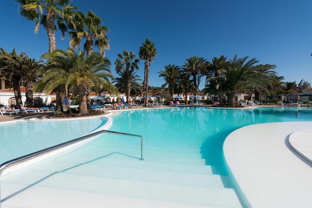 马斯帕洛马斯厄沃金色花园套房酒店的度假村内一座种有棕榈树的大型游泳池