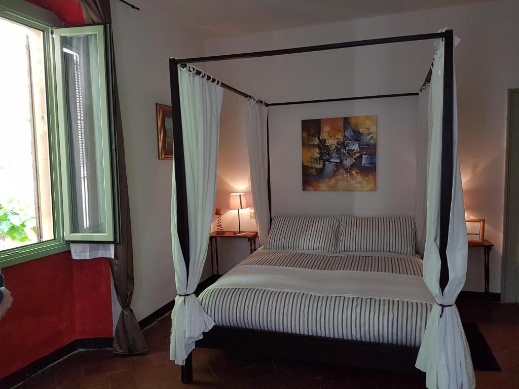 布雷西亚密歇根&莱提住宿加早餐旅馆的窗户客房内的一张带天蓬的床
