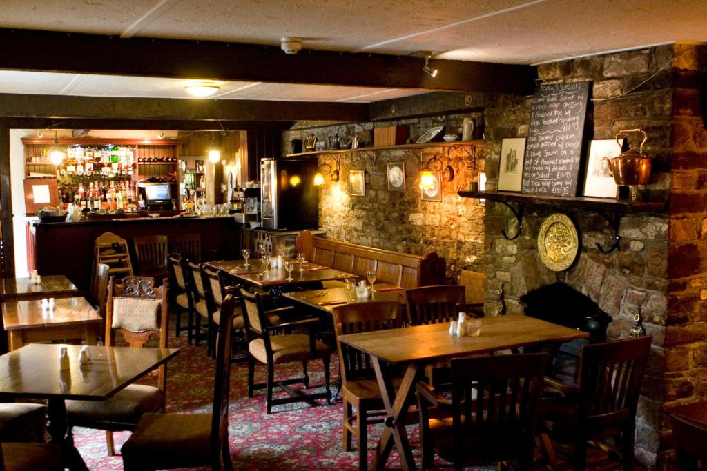 ArmathwaiteFox and Pheasant Inn的一间带桌椅的餐厅和一间酒吧
