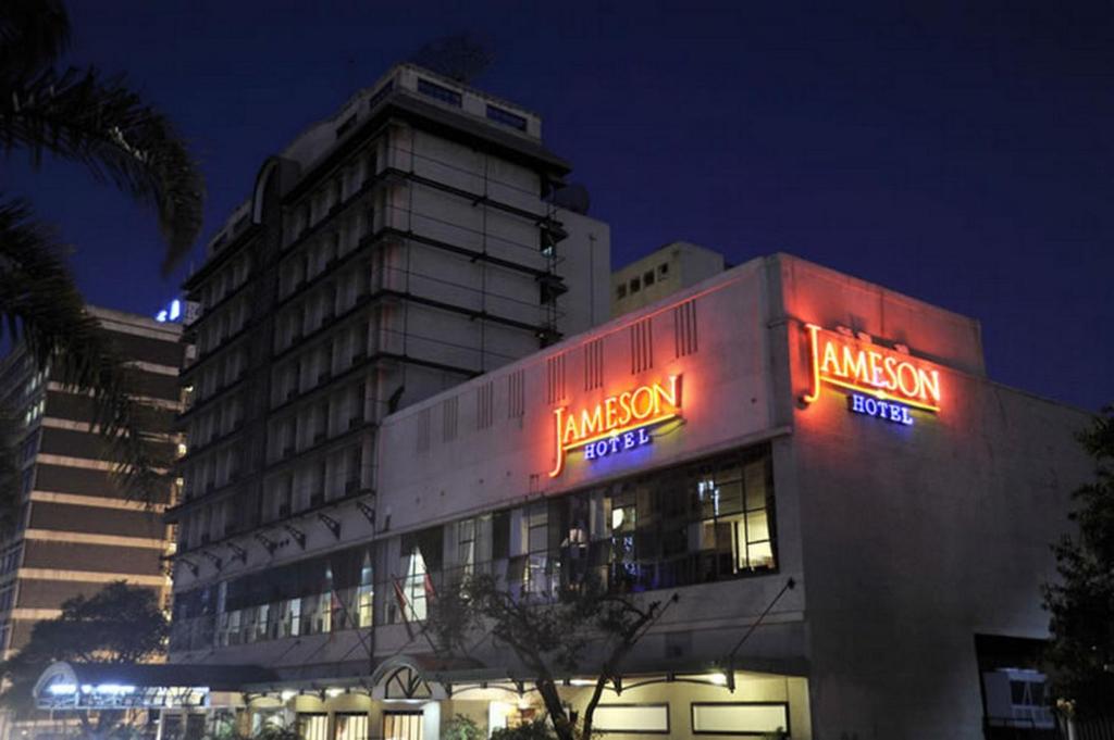 哈拉雷克里斯塔詹姆森酒店的一座大建筑,晚上有 ⁇ 虹灯标志