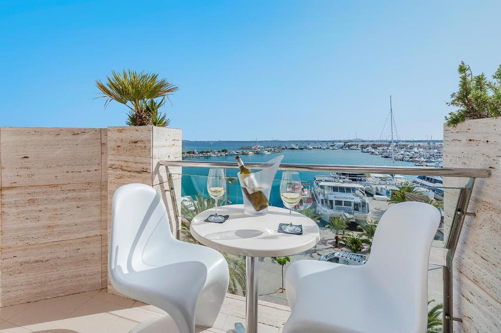 阿尔库迪亚港布瑞滨海旅馆的阳台配有桌椅,享有海港的景致。