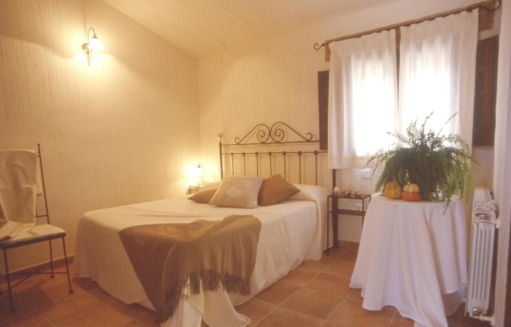 比利亚尔瓦德拉谢拉尼丽亚乡村旅馆的一间卧室配有一张带桌子和窗户的床