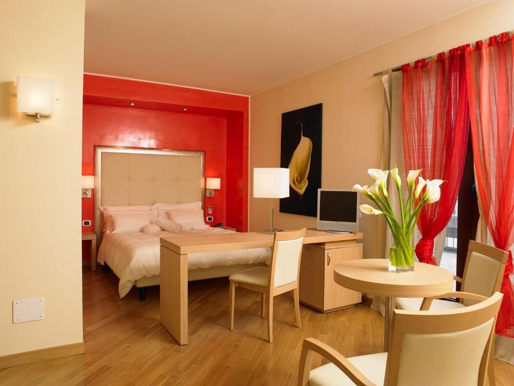 帕多瓦欧罗巴酒店的一间卧室配有一张床、一张桌子和一张桌子