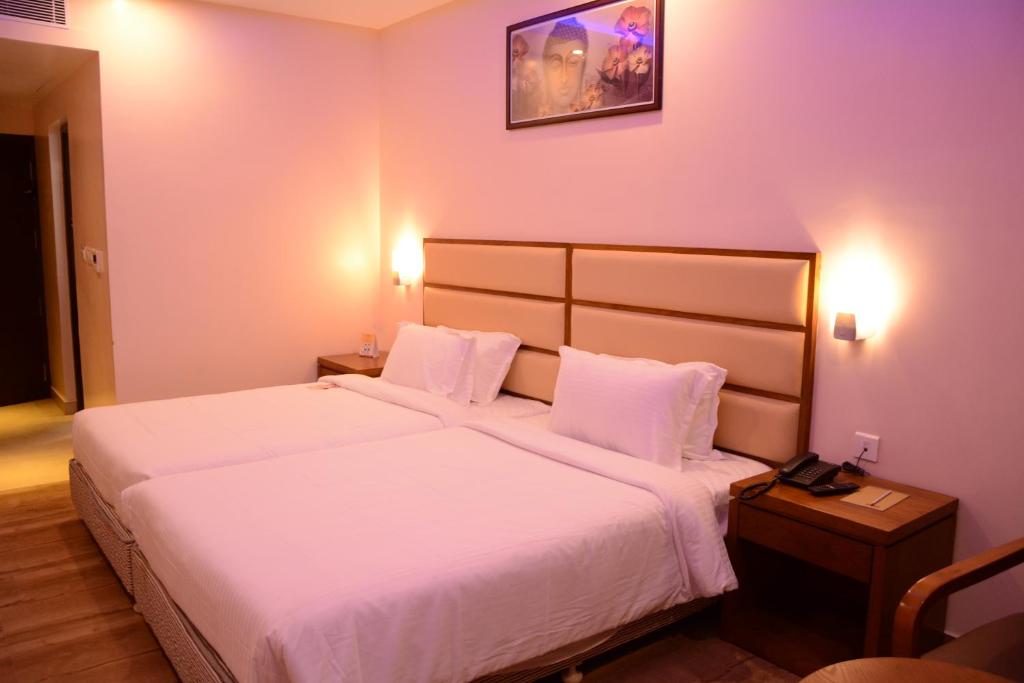 杜蒂戈林卡尼居住酒店的酒店客房带一张大床,带白色床单