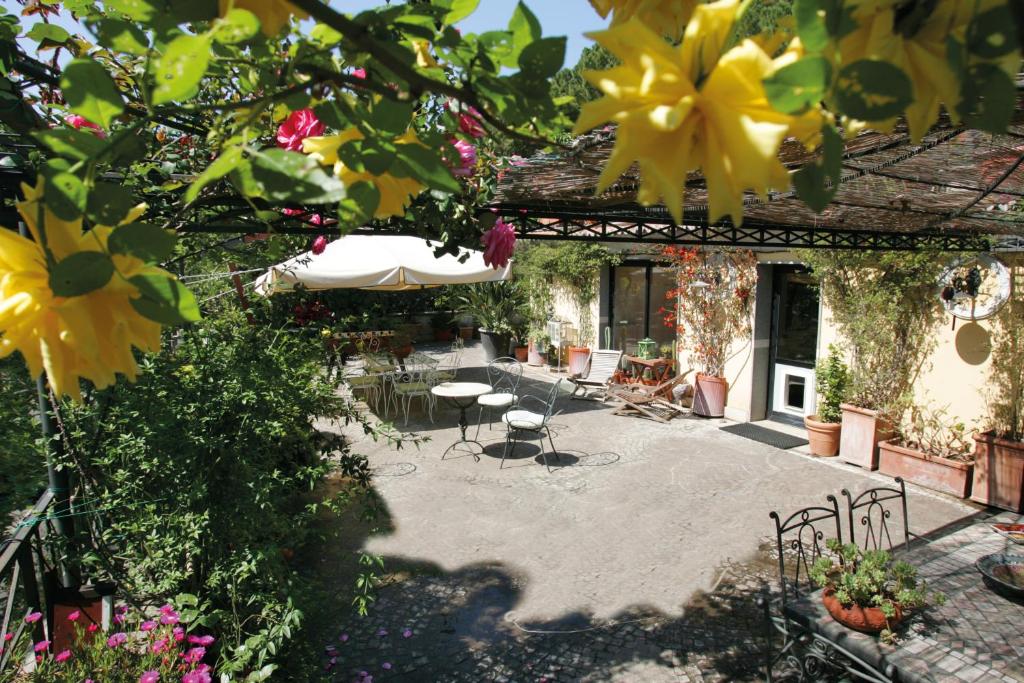 罗马依布姆住宿加早餐酒店的一个带遮阳伞、椅子和鲜花的庭院