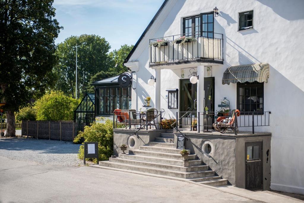 Ljugarn斯玛克雷克克罗格&罗技酒店的白色的房子,设有楼梯和阳台